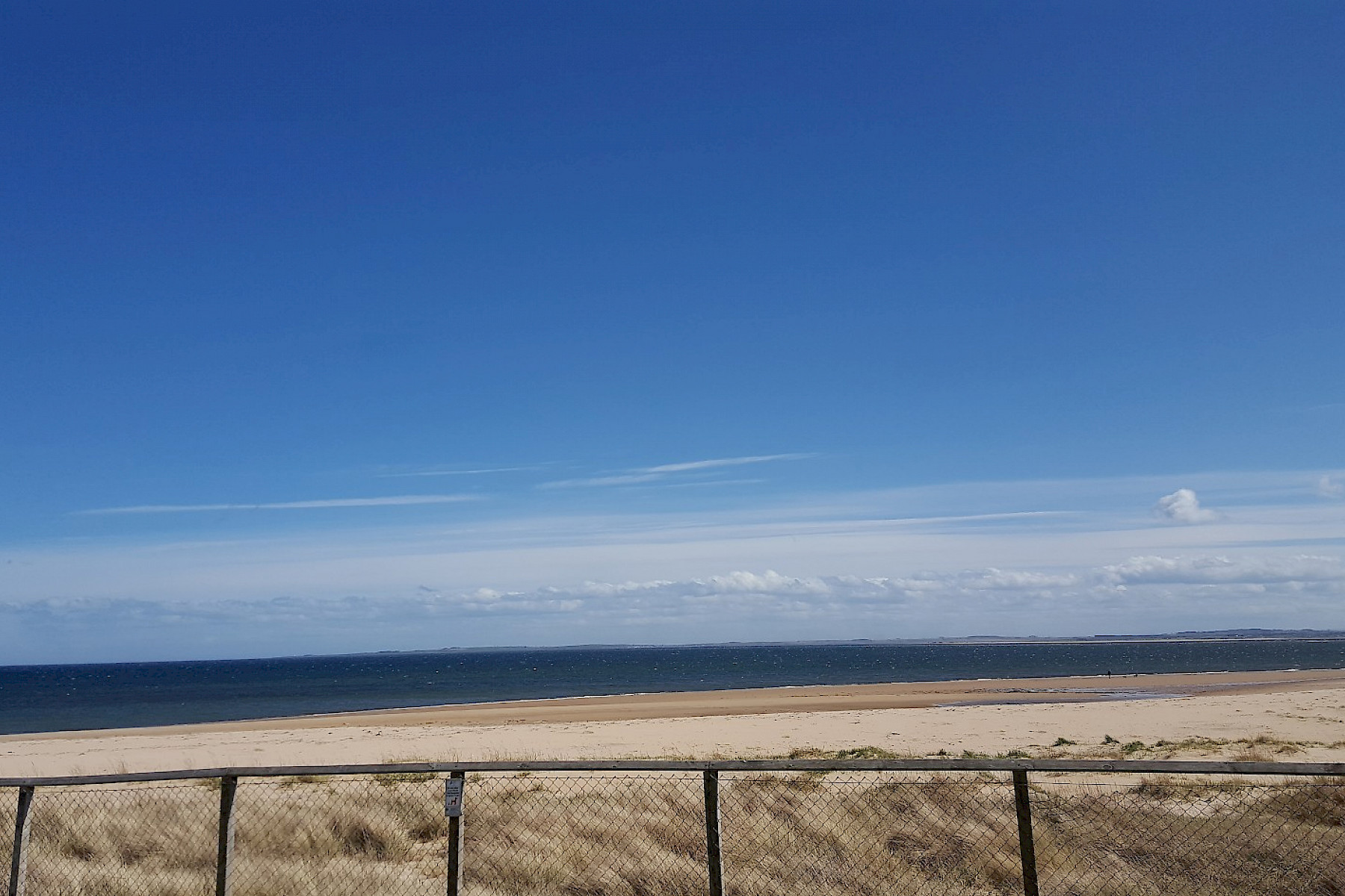 Dornoch image: Wide sandy beach and open blue sky.