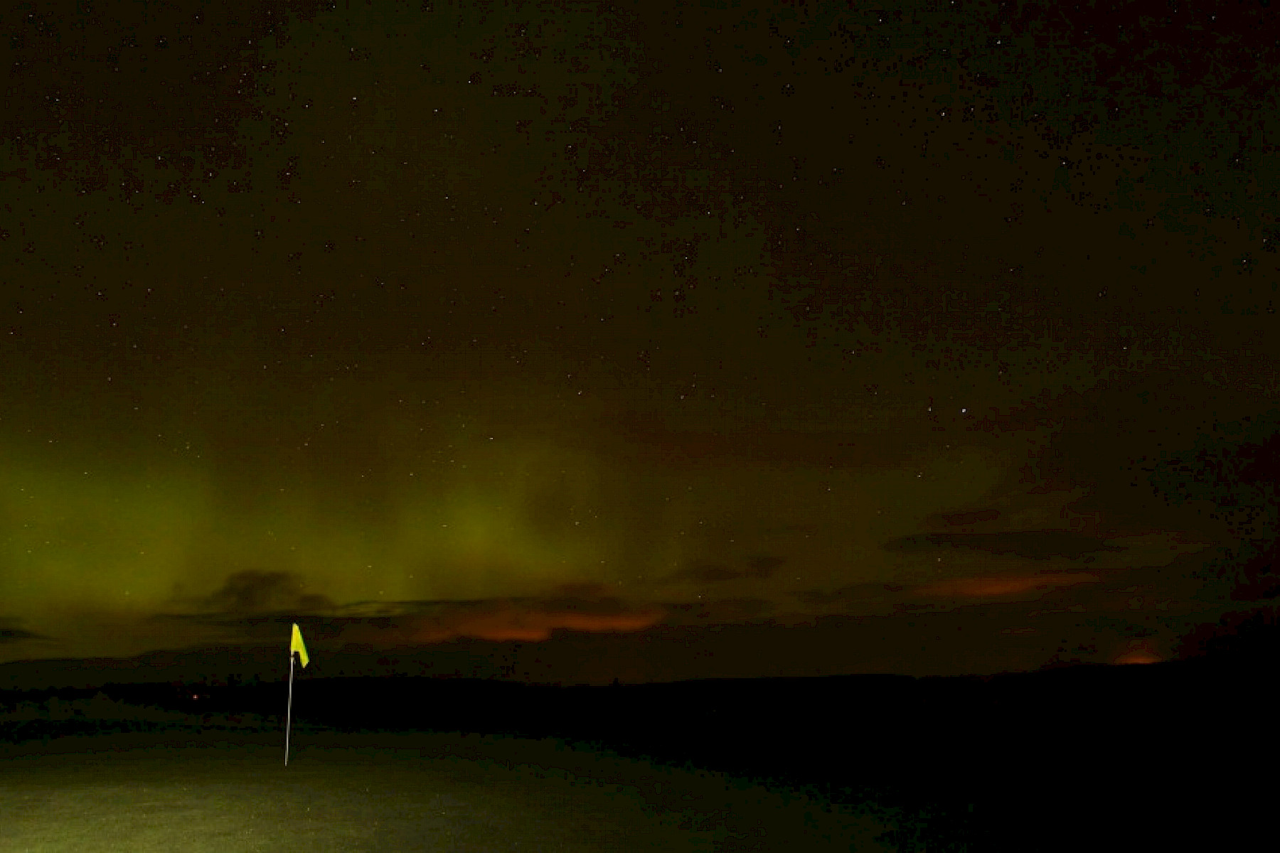 Dornoch image: Aurora Borealis glows in night sky over golf course flag