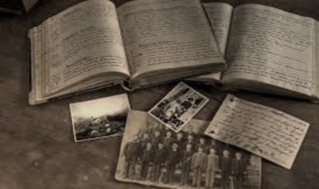 Image: Old black and white photograph of diaries and photos spread out on a table.