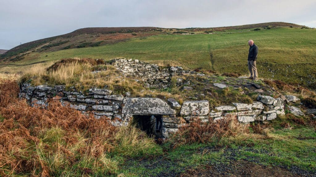 Man standing on top of Ousdale Iron Age historical Broch, near the NC500 at Berriedale, Caithness, North Highlands
