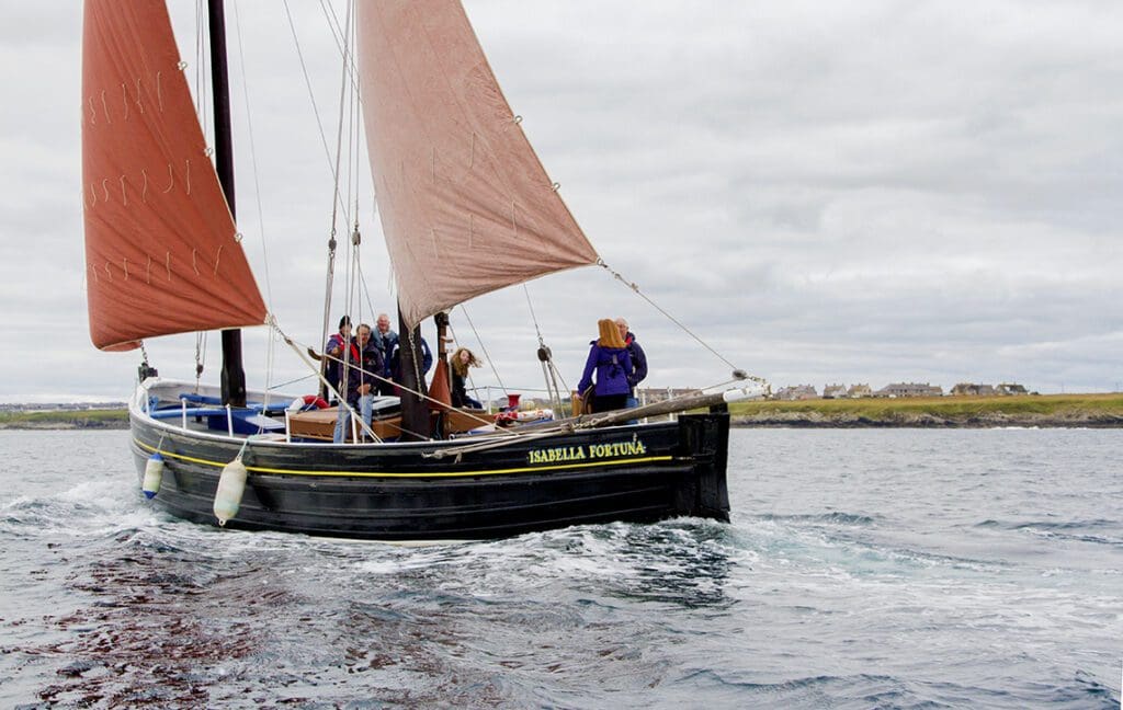 The Isabella Fortuna, an example of a traditional Fifie fishing vessel, sailing off the North Coast of Caithness with visitors learning about the history.