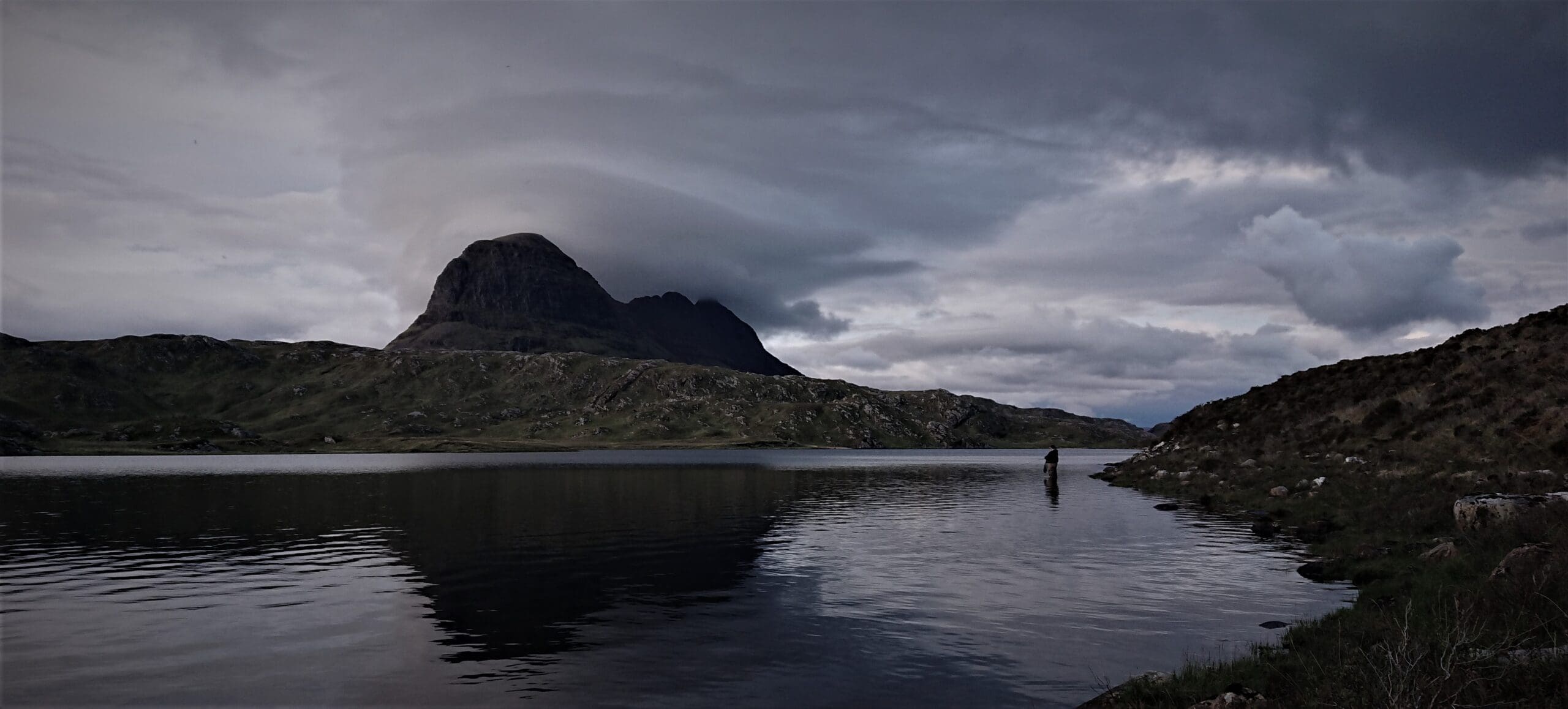 Stewart Yates from Assynt Fly Fishing, fishing a loch with Suilven towering in the background, the ultimate way to getaway from it all in the Highlands. 