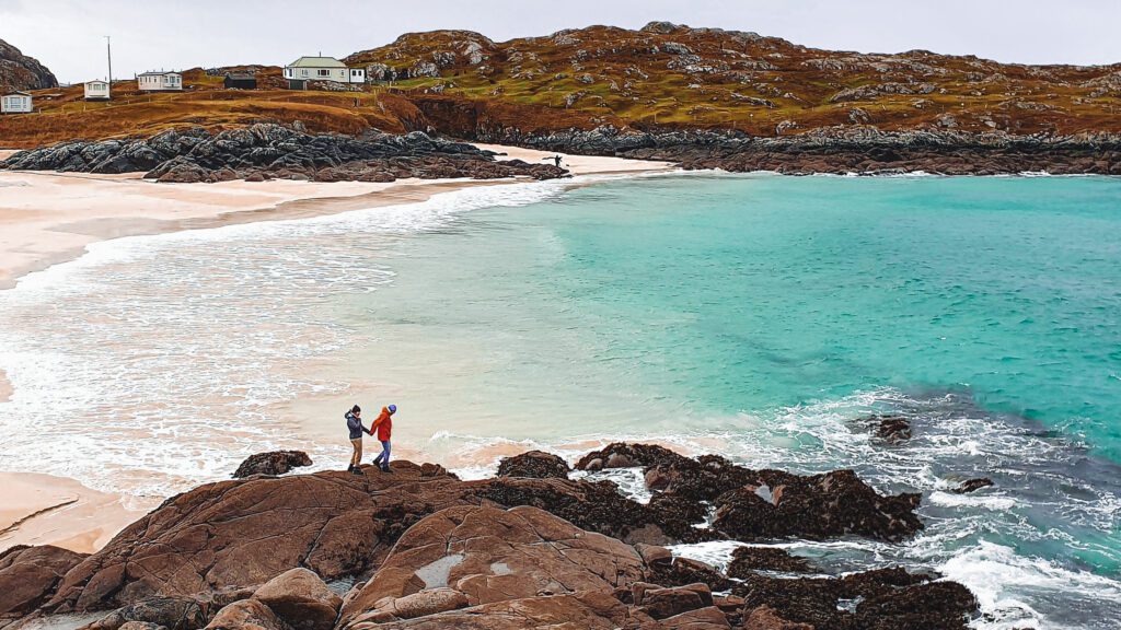Couple in winter on Achmelvich Beach, Sutherland, North Coast 500
