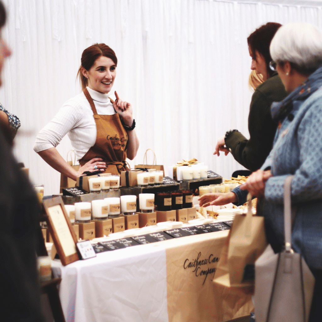 A woman running the Caithness Candle Company stall at Taste North, located in Wick, Scotland.