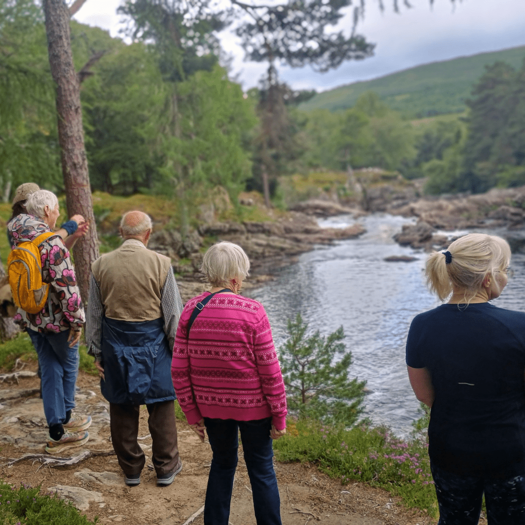 A group taking a walk by the river at Invercassley Walk, Central Sutherland, North Highlands
