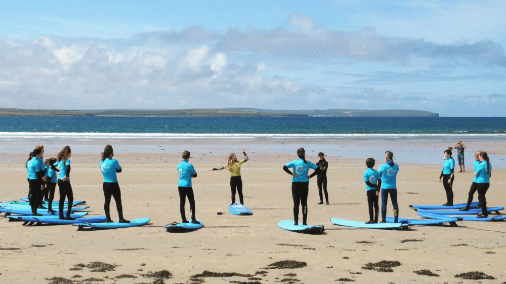 A group of surfers stood on Dunnet Beach, Caithness, Scotland,