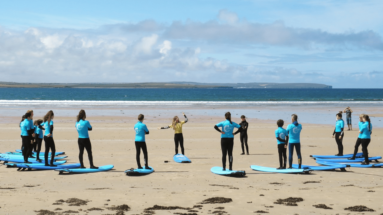 A group of surfers stood on Dunnet Beach, Caithness, Activities and sport in the North Highlands