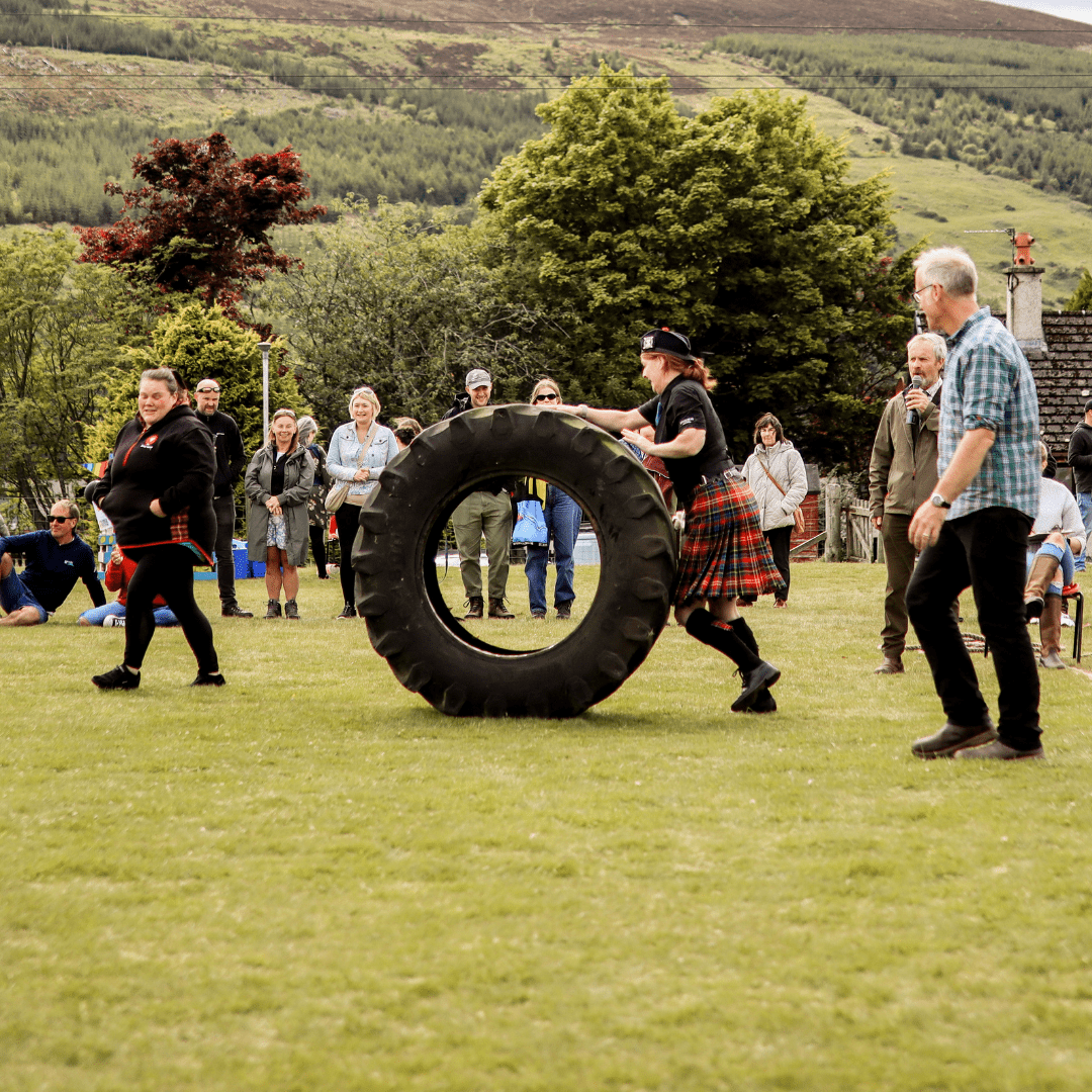 Tyre rolling in traditional Scottish kilt at Rogart Gala, Central Sutherland, North Highlands