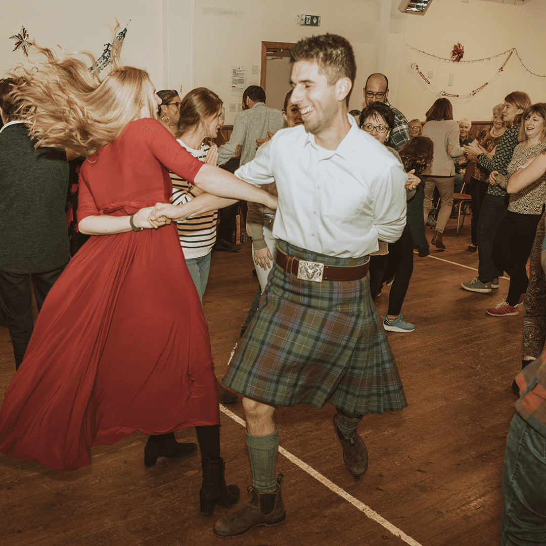 A couple dancing among the crowd at a traditional Scottish ceilidh, East Sutherland, North Highlands
