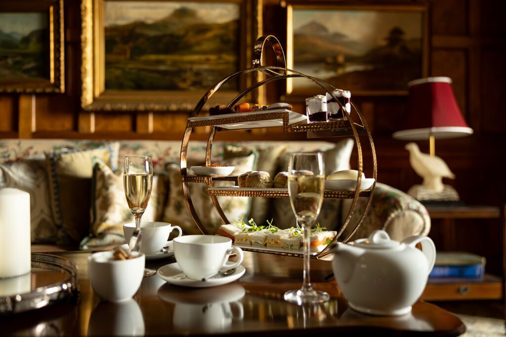 A coffee table laid out with champagne and cakes, inside a cosy seating area in Dornoch Station Hotel,, Sutherland, along the NC500