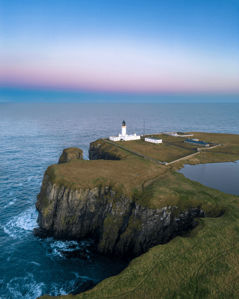 Aerial view of Cape Wrath Lighthouse, a clear blue sky with the cliffs in view. Attractions and landmarks.