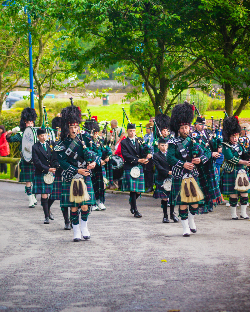 A pipe band walking down the street in Wick, Caithness, Scotland