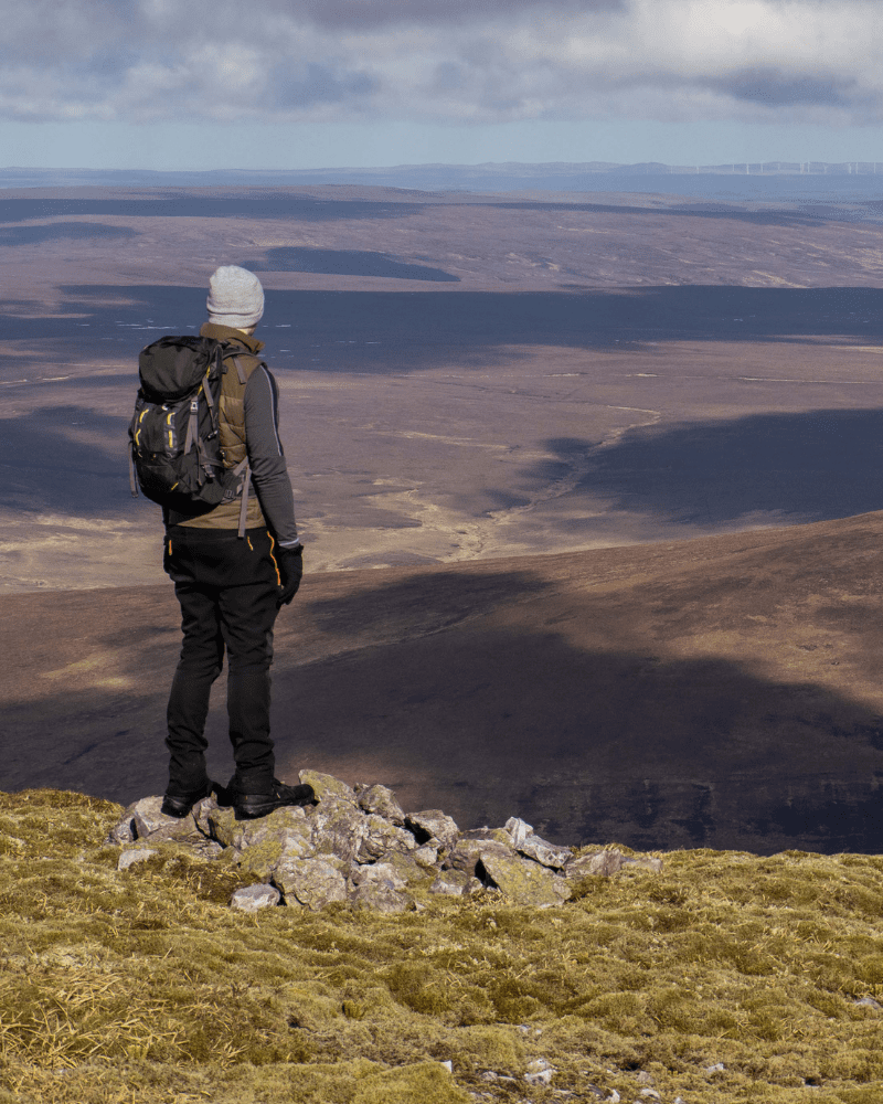 A man stood facing away from the Camera, on Morven, in Sutherland, Scotland.
