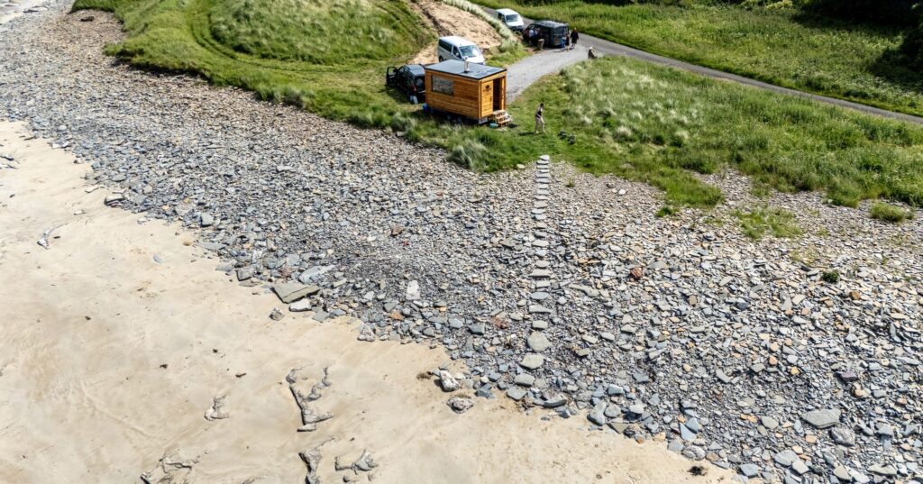 Clach Mara Sauna on the edge of Castletown beach, with a stone path down to the sand, located in Caithness, Scotland