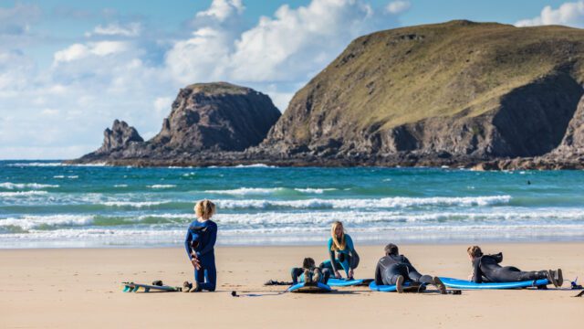 Surf lesson at Farr Bay near Bettyhill on Scotland’s NC500 with North Coast Watersports instructors guiding beginners in clear blue waters.