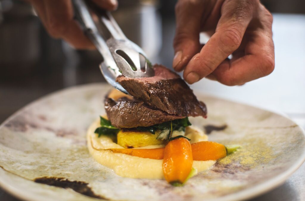 A fine dining meal of venison being plated up by the chef at Eddrachilles Hotel in North West Sutherland.