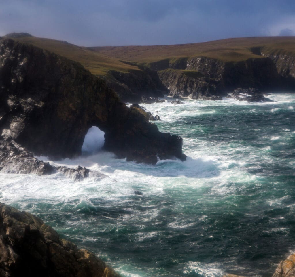 Dramatic sea scene of waves hitting a cove at Strathy Beach, North Highlands