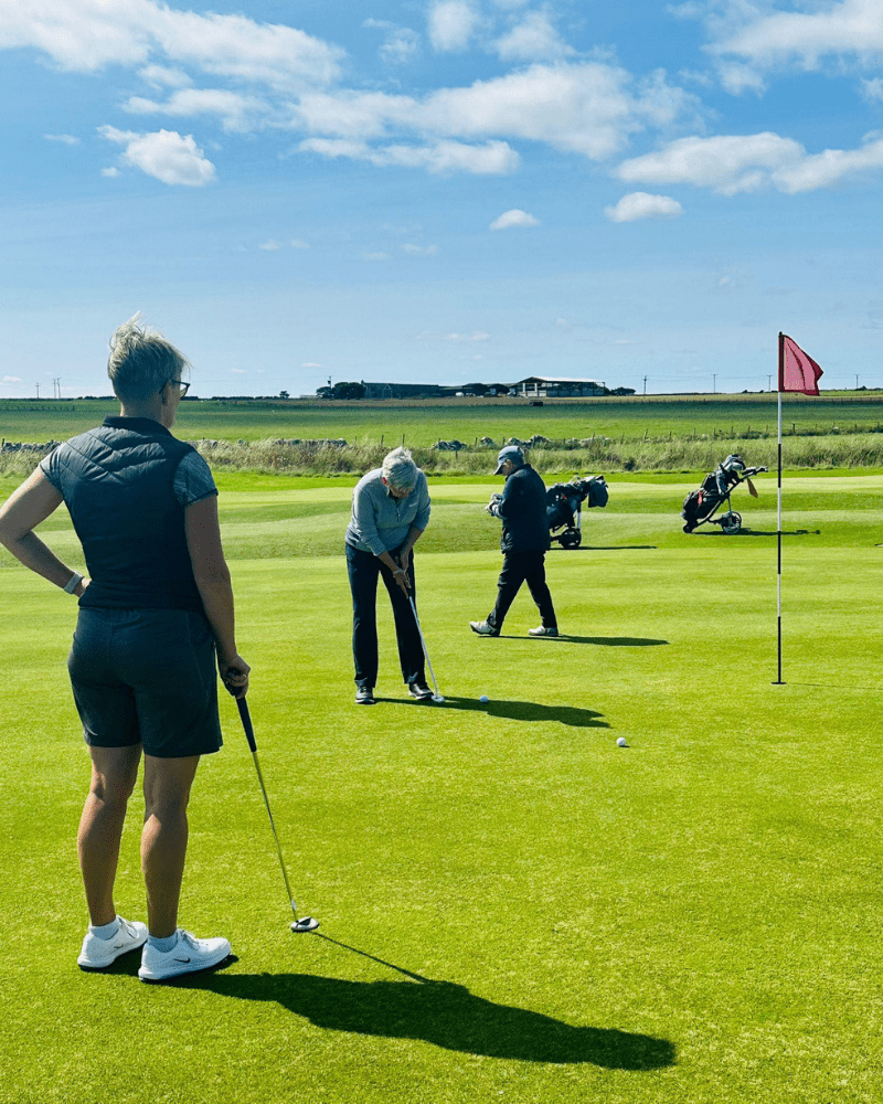 A group of golfers practicing on the green at Wick Golf Club, in Reiss, Caithness, North Highland