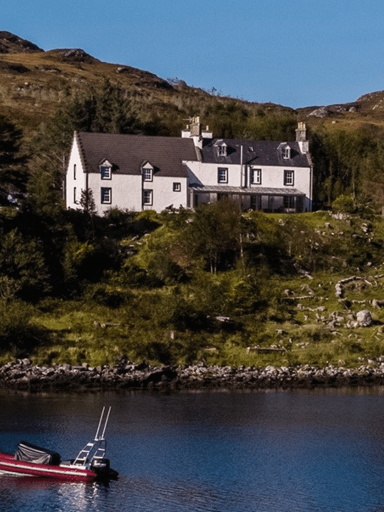 Eddrachilles Hotel overlooking a fishing boat in Badcall Bay, North West Highlands on Nc500