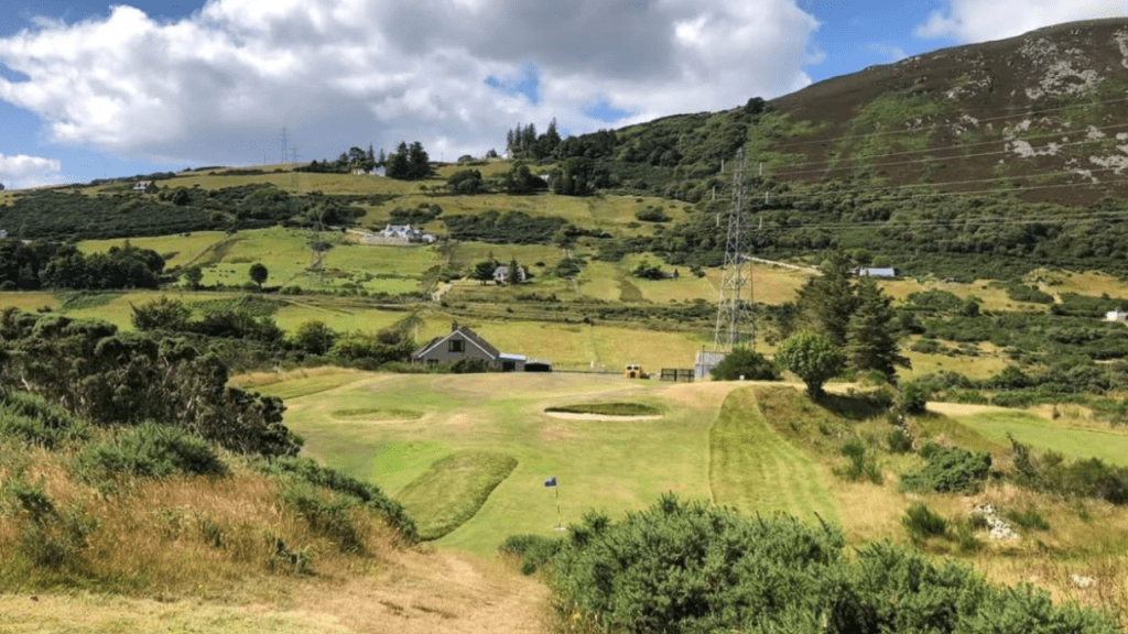 A view across helmsdale golf course, showing the fields and house surrounding it, in Sutherland, North Highlands