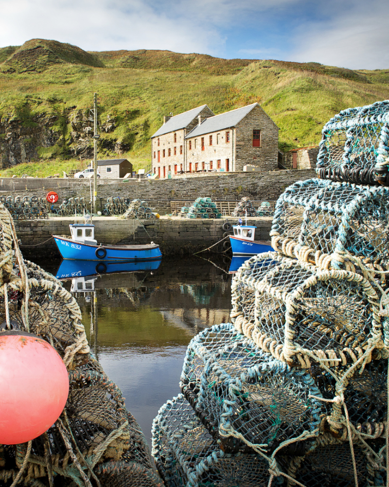 Waterlines in Lybster view from across the harbour, between two fishing baskets. in Caithness, North highlands