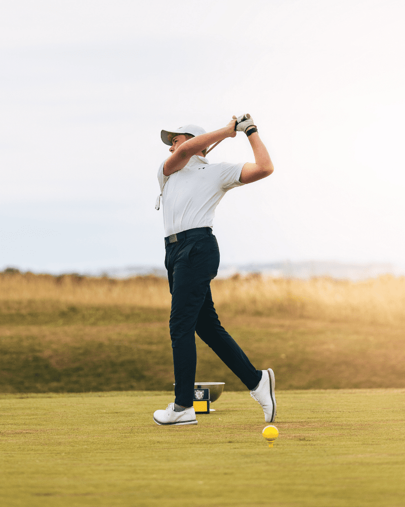 A man mid swing of his golf club, at the Royal Dornoch Golf Club, Sutherland, North Highlands