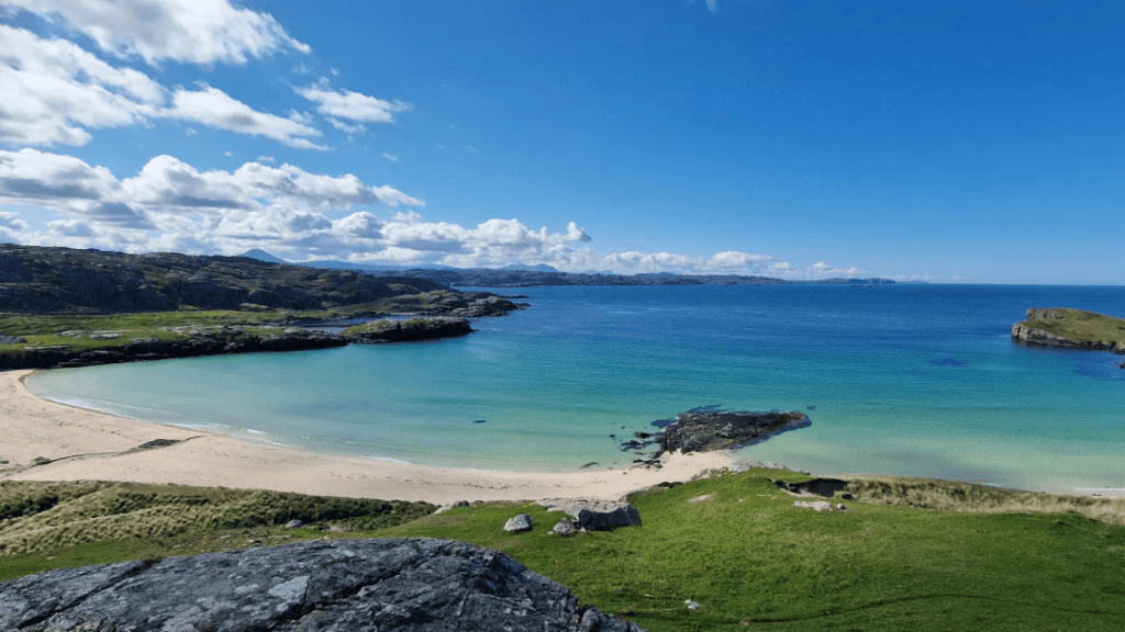 A scenic beach with yellow sand and turquoise sea, in the North Highlands